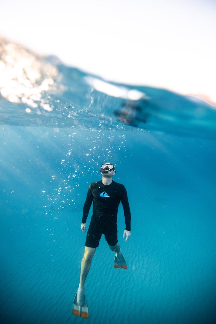 Man snorkeling in vibrant Hawaiian waters, showcasing underwater exploration and aquatic adventure.